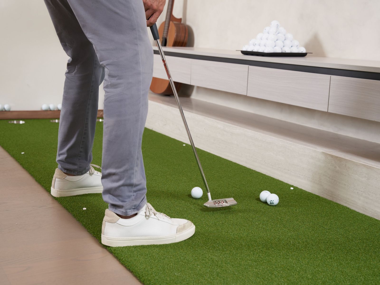Golfare som puttar på en puttmatta inomhus